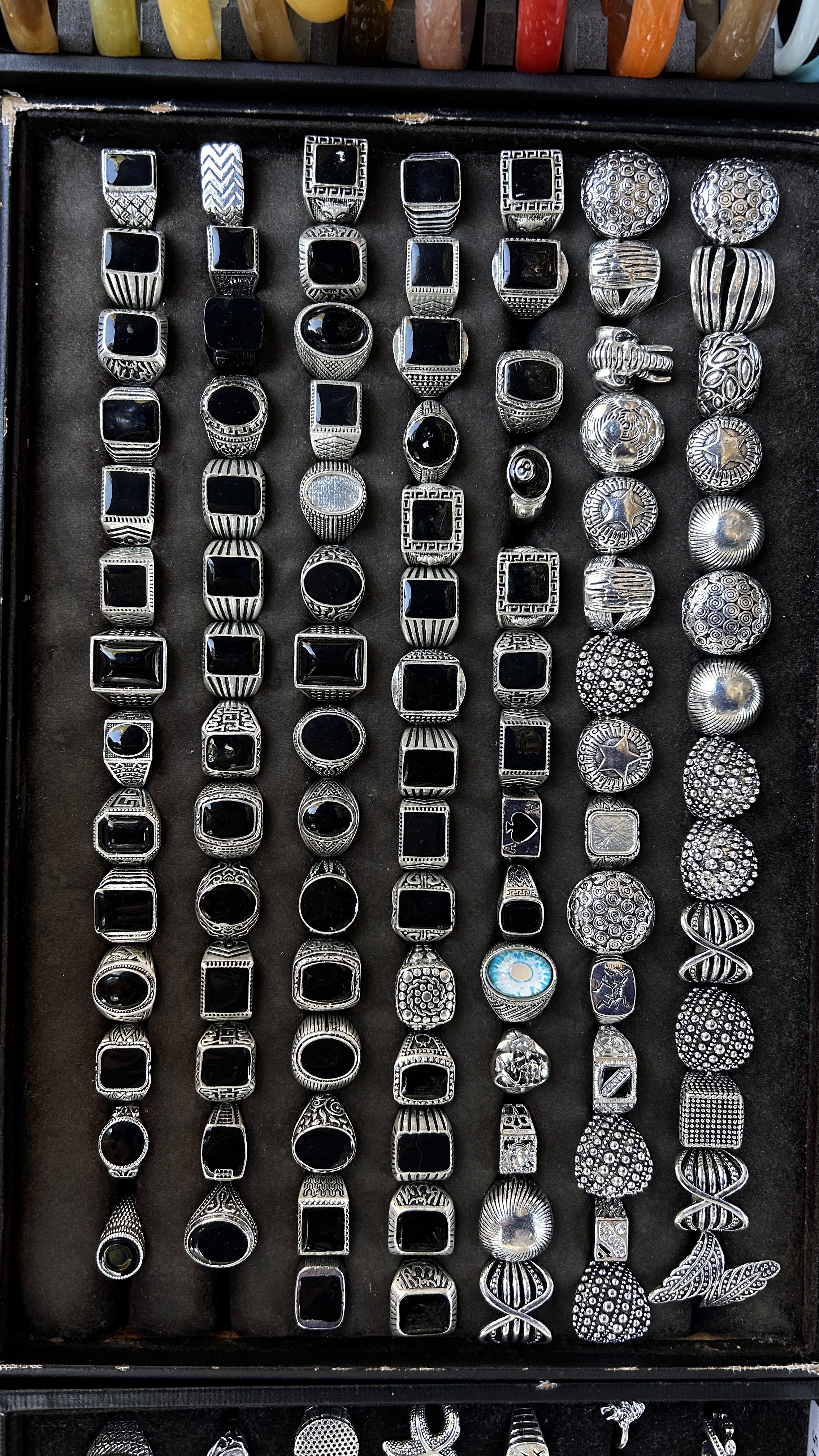 Silver-tone rings with glossy black stones and engraved details.