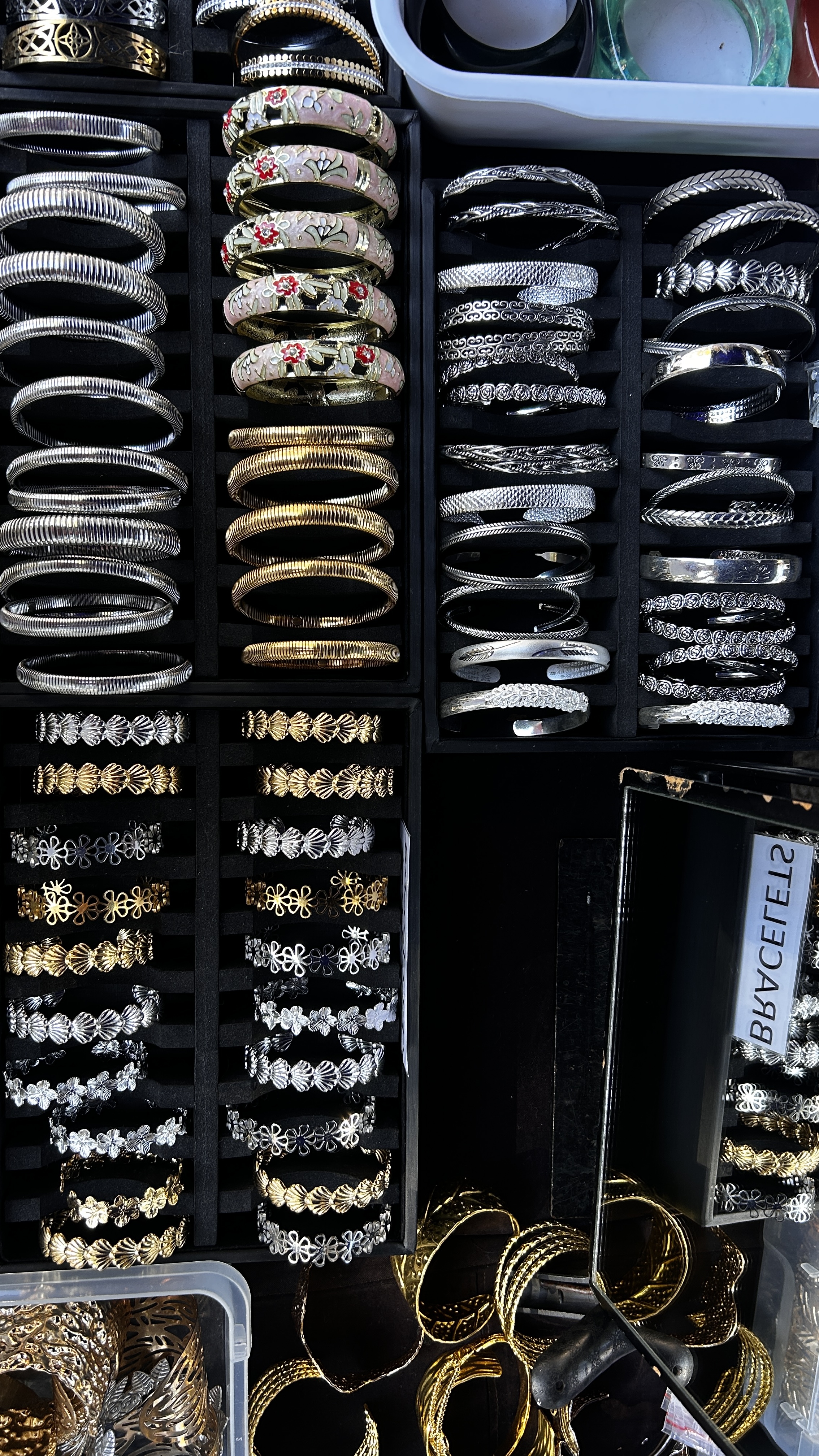 Gold and silver-tone cuff bracelets, including floral and textured designs.