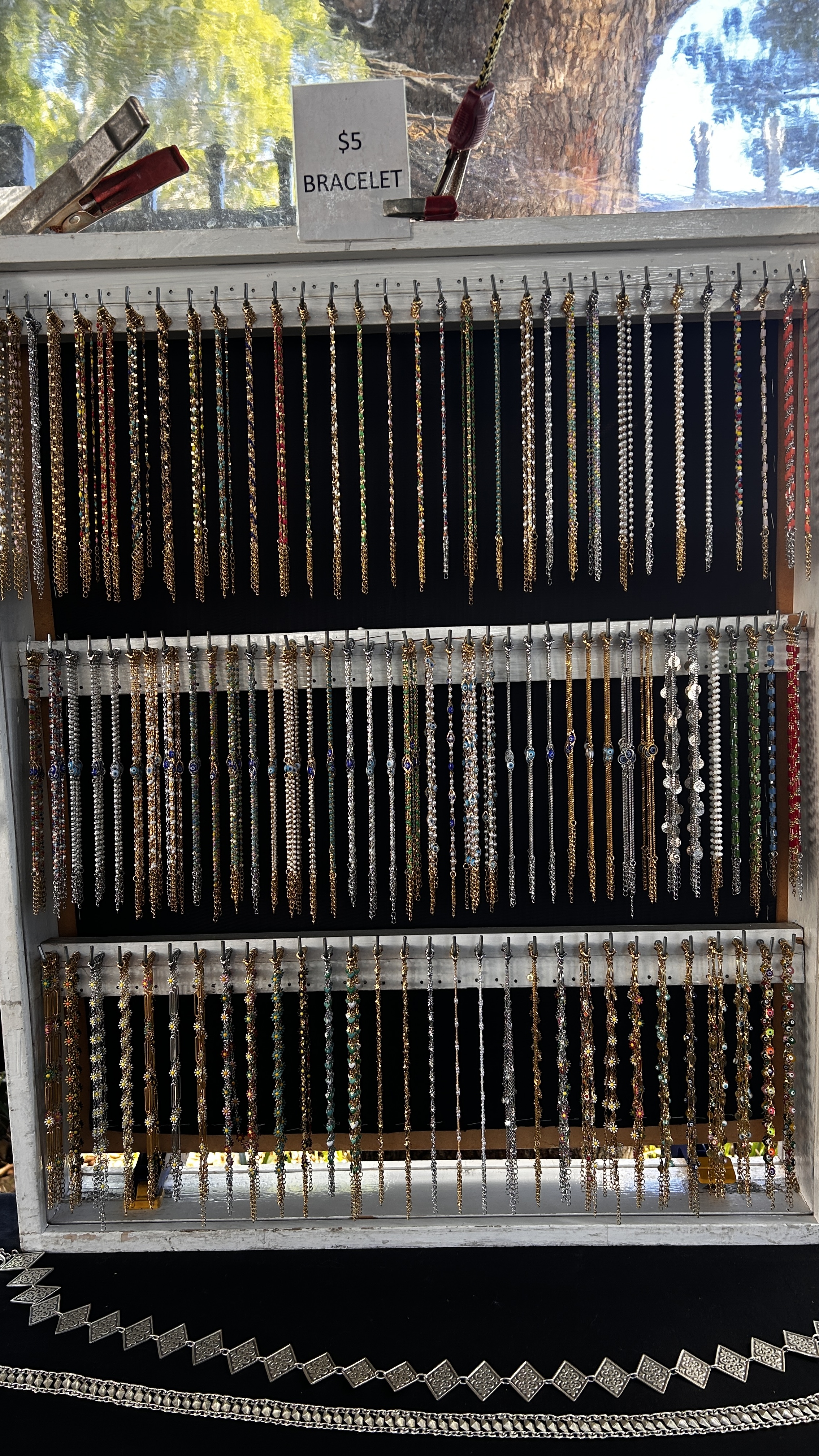 A full market display of delicate chain and beaded bracelets.
