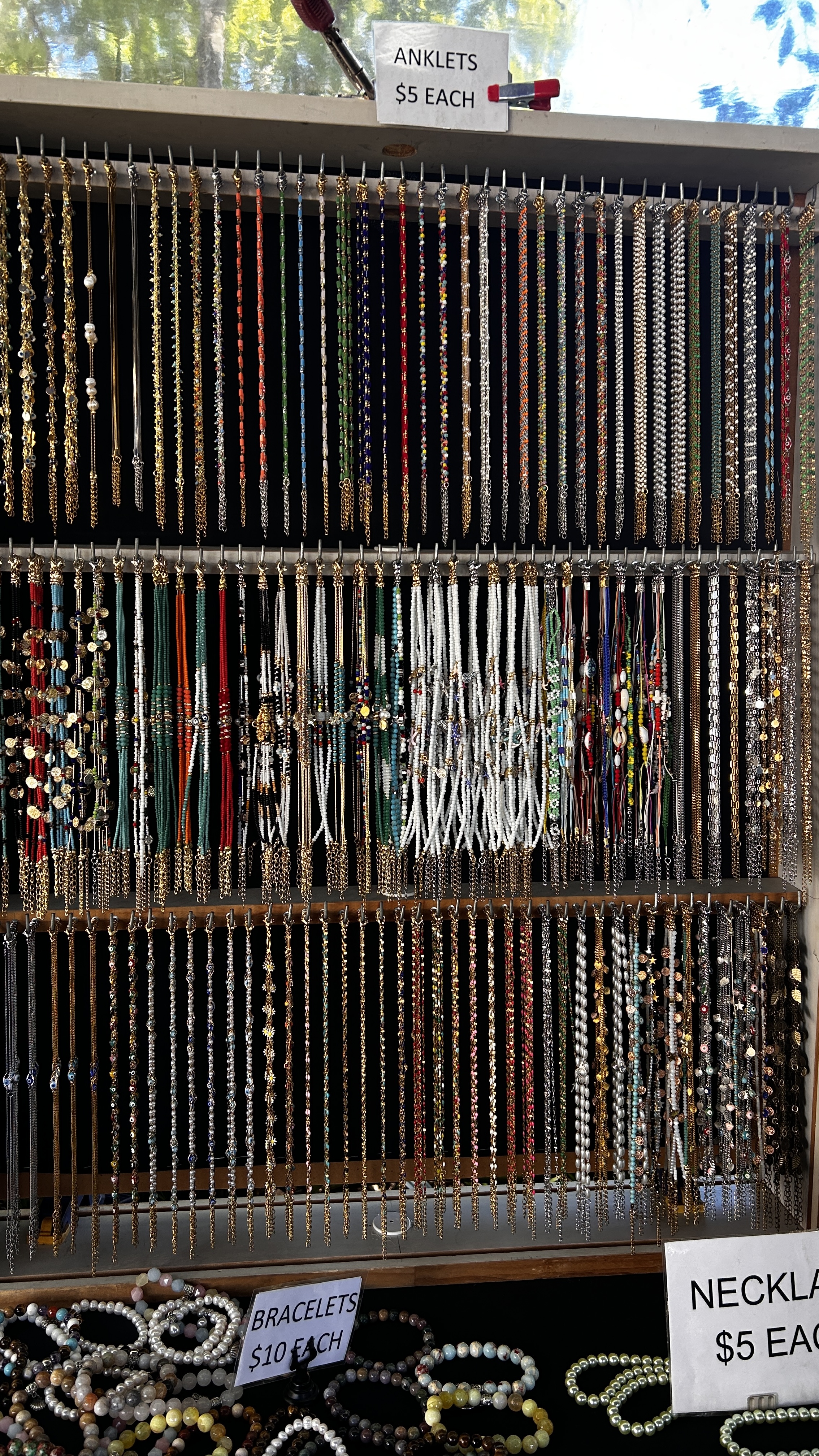 Anklets, bracelets and beaded pieces on a full market display.